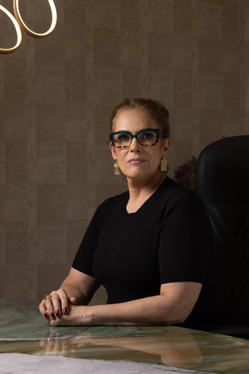 Dra. Iolanda Abreu sentada à mesa de atendimento